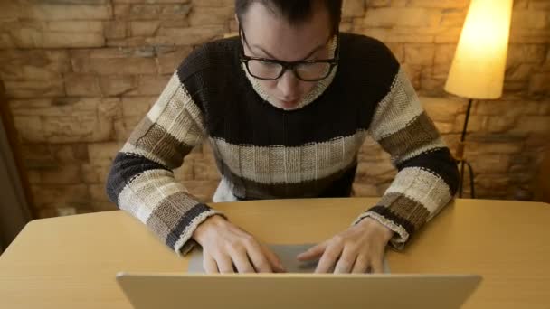 Giovane uomo che sembra scioccato mentre si utilizza il computer portatile a casa — Video Stock