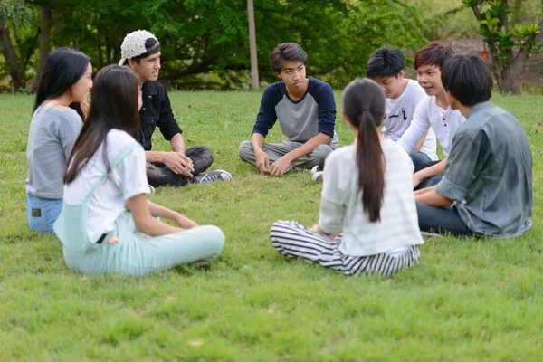 Счастливая молодая компания друзей веселится вместе в парке — стоковое фото