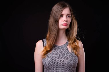 Siyah arka planda giyinmiş güzel İskandinav bir kadının stüdyo fotoğrafı.