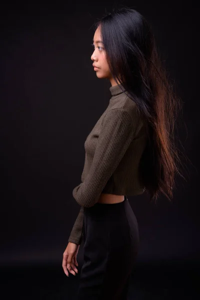 演播室拍摄的年轻美丽的亚洲女人穿着黑色背景的高领毛衣 — 图库照片