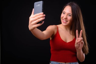 Studio shot of young multi ethnic beautiful woman against black background