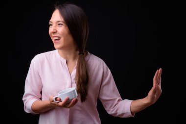Studio shot of young multi ethnic beautiful businesswoman against black background