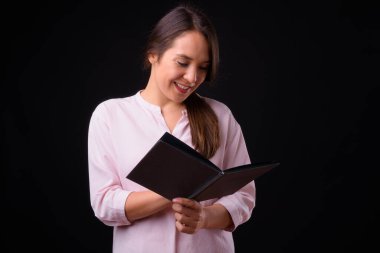 Studio shot of young multi ethnic beautiful businesswoman against black background