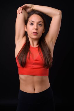 Studio shot of young multi ethnic beautiful woman ready for gym against black background