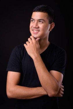 Genç yakışıklı Asya adam siyah arka plan stüdyo çekim