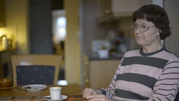 Счастливая пожилая женщина разговаривает по телефону дома — стоковое видео