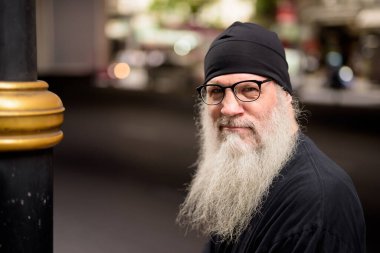 Şehrin sokaklarında yakışıklı, sakallı hippi bir adamın portresi.