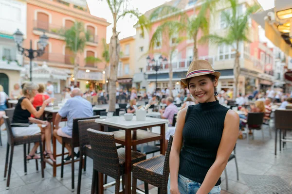 Portrait of young beautiful Asian tourist woman at the restaurant outdoors in Spain