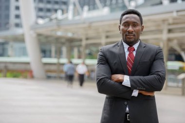 Genç ve yakışıklı Afrikalı işadamının portresi şehrin modern yapısına karşı.