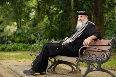 Portrait of mature bearded hipster man at the park outdoors