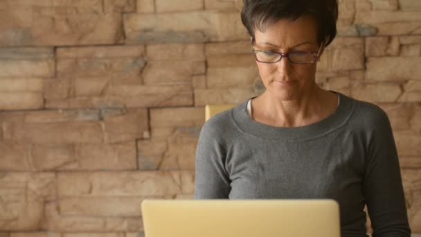 Felnőtt gyönyörű nő gondolkodás használata közben laptop szemüveg — Stock videók