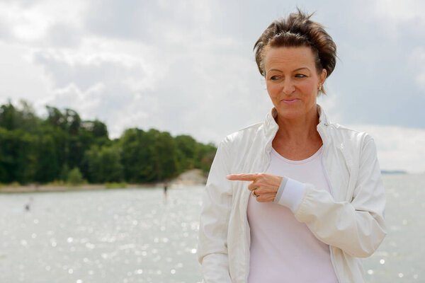 Mature beautiful woman against scenic view of the lake