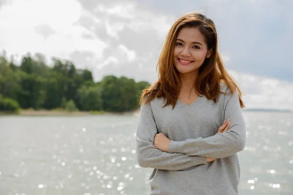 Jonge mooie Aziatische vrouw tegen schilderachtig uitzicht op het meer — Stockfoto