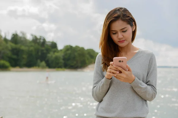 Ung vacker asiatisk kvinna mot vacker utsikt över sjön — Stockfoto
