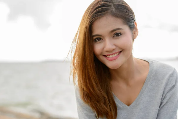 Mladý krásný asijské žena proti scénický pohled na jezero — Stock fotografie