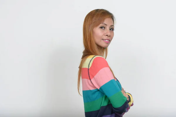 Studio shot of mature Filipino woman wearing cardigan sweater against white background
