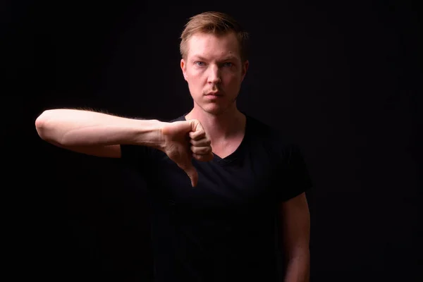 Портрет напруженого молодого чоловіка, що дає великі пальці вниз — стокове фото
