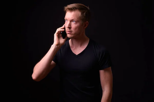 Портрет молодого красивого чоловіка, який думає і розмовляє по телефону — стокове фото