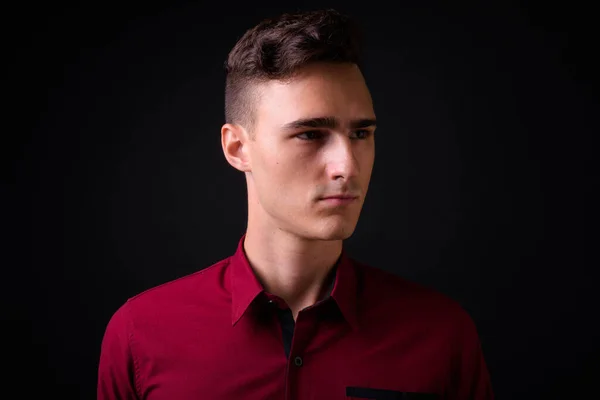 演播室拍摄的年轻英俊商人身穿红衫 背景为黑色 — 图库照片