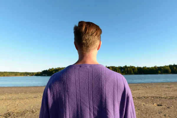 Portrait of young handsome Scandinavian man against beautiful scenery of the shore
