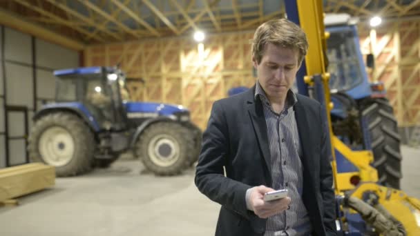 Tânăr om de afaceri frumos folosind telefonul în interiorul șantierului de construcții din lemn — Videoclip de stoc
