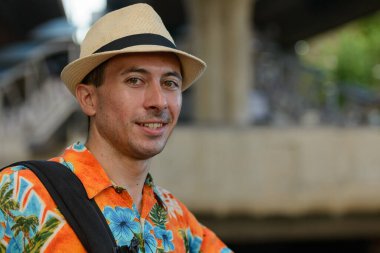 Bangkok 'taki nehir manzarasına karşı rıhtımdaki yakışıklı turistin portresi.
