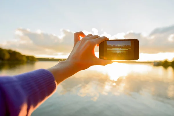 Hände eines jungen Mannes, der Fotos mit dem Handy des schönen Sonnenuntergangs macht — Stockfoto