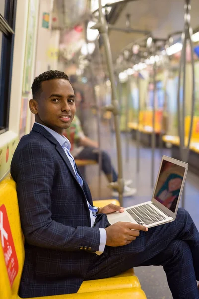 市内電車の中でスーツを着ている若いハンサムなアフリカのビジネスマンの肖像画 — ストック写真