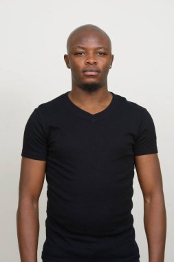 Beyaz arka planda genç, yakışıklı, kel Afrikalı adamın stüdyo fotoğrafı.
