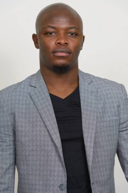 Studio shot of young handsome bald African businessman in suit against white background