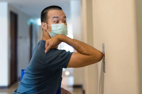 Portrait of young Asian man with mask for protection from corona virus outbreak practicing proper hygiene etiquette