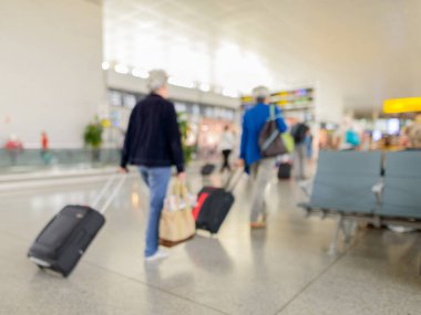 Portrait of defocused terminal departure check-in at airport with walking travelers