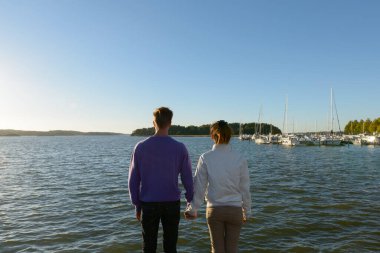 Portrait of young Scandinavian man and young Asian woman as multi ethnic couple together and in love at the pier outdoors