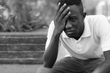 Portrait of young African man at modern building in the city outdoors in black and white