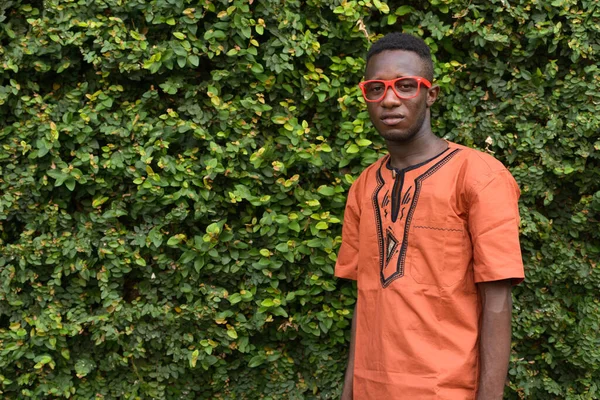 Портрет Молодого Африканця Одягненого Традиційний Одяг Проти Зеленого Живоплоту — стокове фото