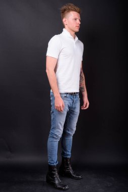 Studio shot of rebellious man as punk rocker against black background