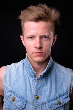 Studio shot of rebellious man as punk rocker against black background
