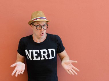 Portrait of young handsome tourist man as nerd against colored background outdoors