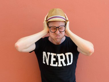 Portrait of young handsome tourist man as nerd against colored background outdoors