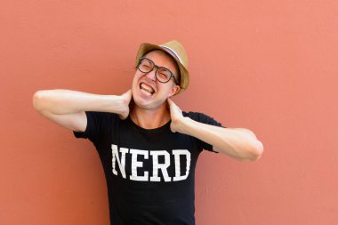 Portrait of young handsome tourist man as nerd against colored background outdoors