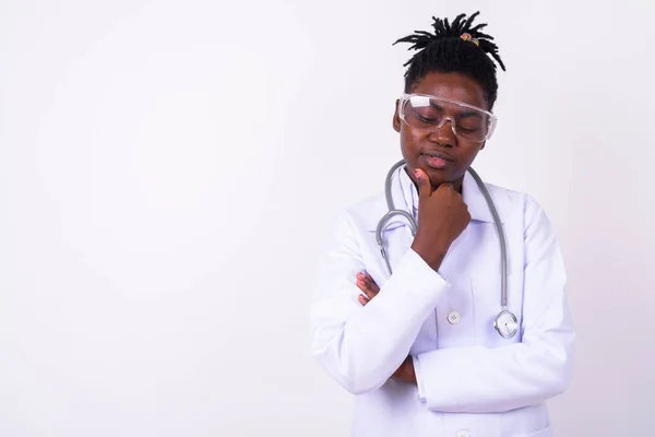 Studio shot of young beautiful African woman doctor against white background