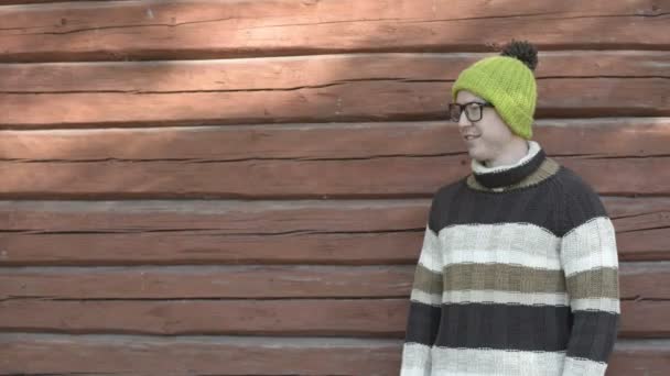 Glücklicher junger gutaussehender Mann lächelt im Herbst gegen Holzwand — Stockvideo