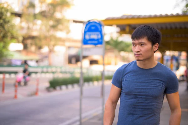 Portrait de jeune homme asiatique à l'arrêt de bus — Photo