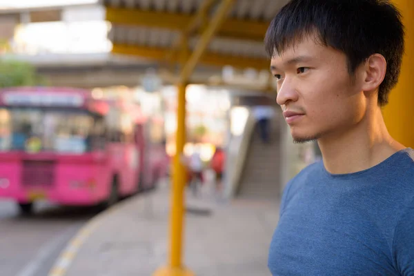 Портрет молодого азіата на автобусній зупинці. — стокове фото