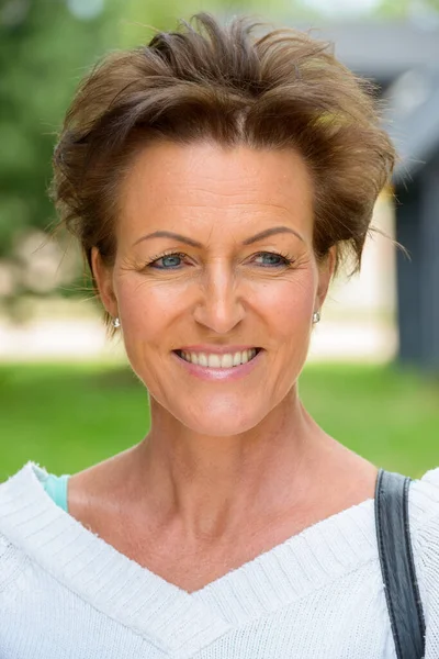 Gesicht einer reifen schönen Frau mit kurzen Haaren im Park — Stockfoto