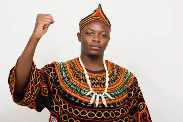 Fiatal jóképű afrikai férfi hagyományos ruházati ököllel emelt — Stock Fotó