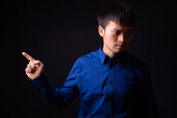 Portrét mladého asijského podnikatele ukazující prstem — Stock fotografie