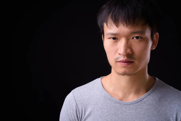 Porträt eines jungen asiatischen Mannes, der in die Kamera blickt — Stockfoto