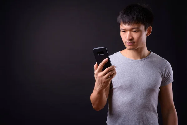 Portrait of young Asian man using phone — Stock Photo, Image