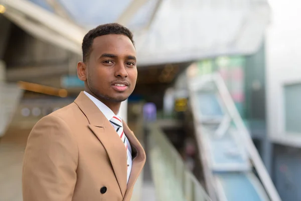 Glad ung vacker afrikansk affärsman på gångbro i staden — Stockfoto